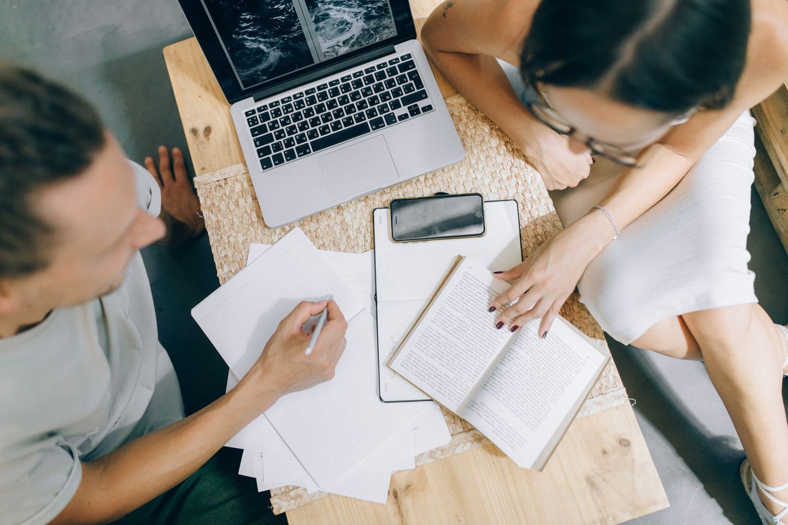 Two people reviewing printed legal documents together at a wooden table