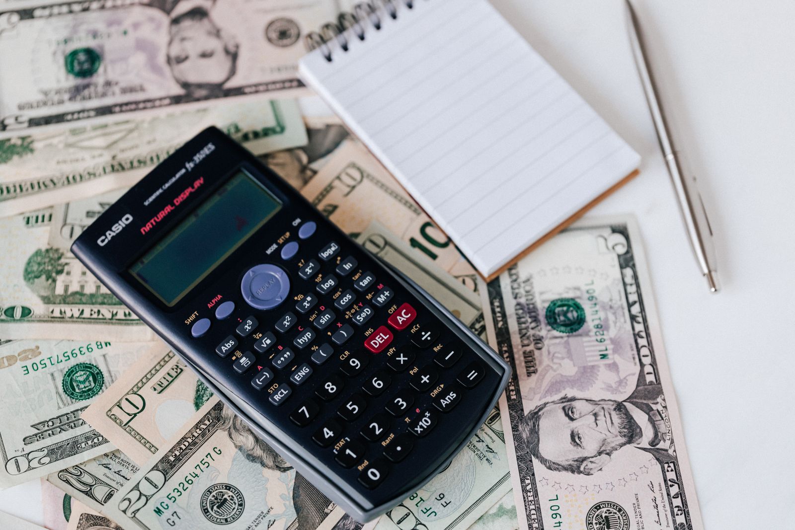 Person calculating document translation costs with a calculator and paperwork on a desk